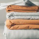 Stack of clean bed sheets on table