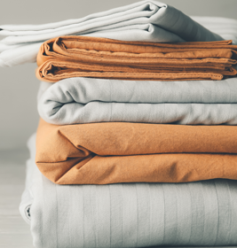Stack of clean bed sheets on table