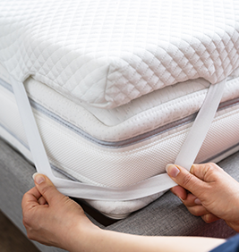 Mattress Topper Being Laid On Top Of The Bed